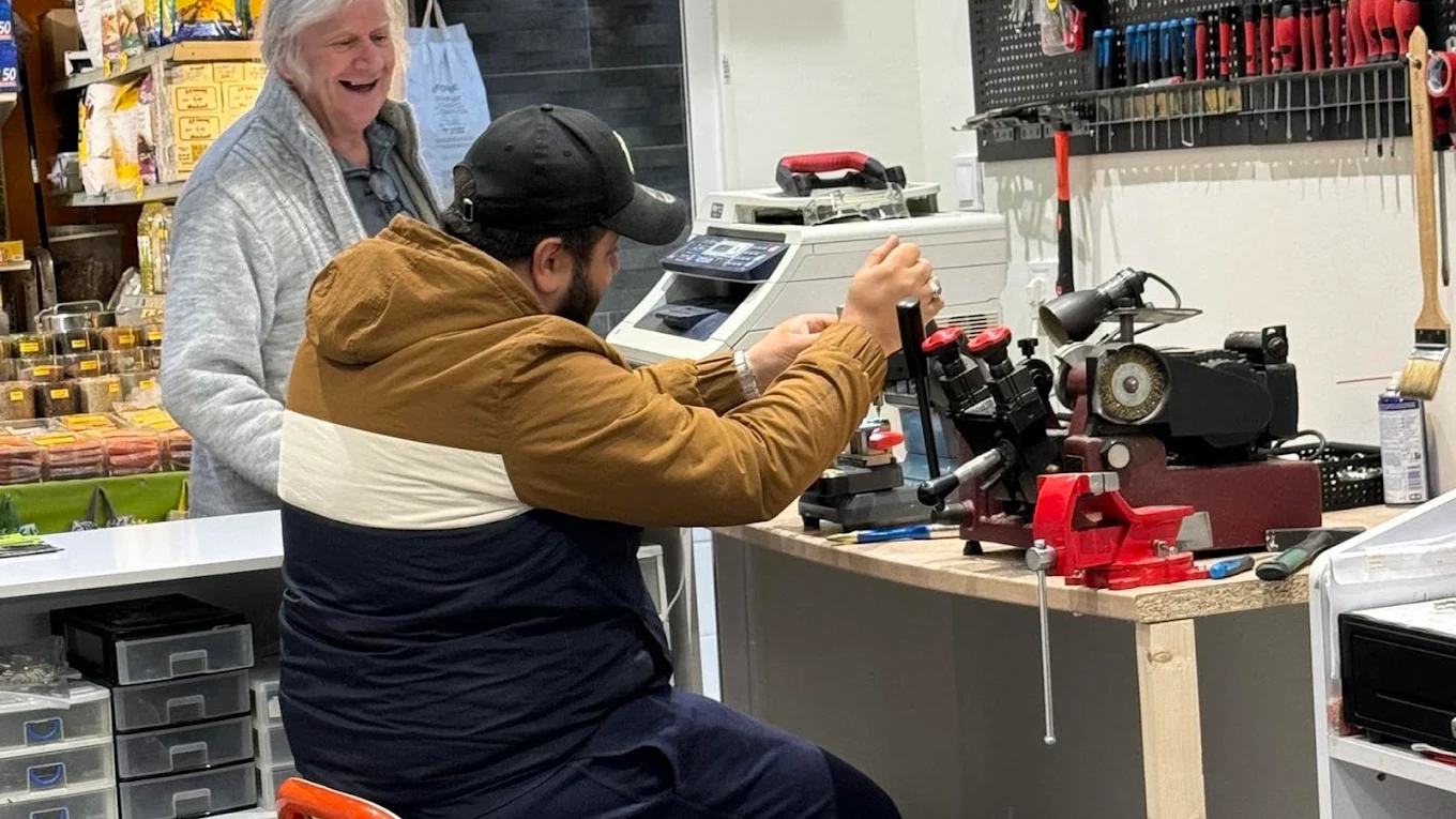 L'artisan taille une clé devant une cliente